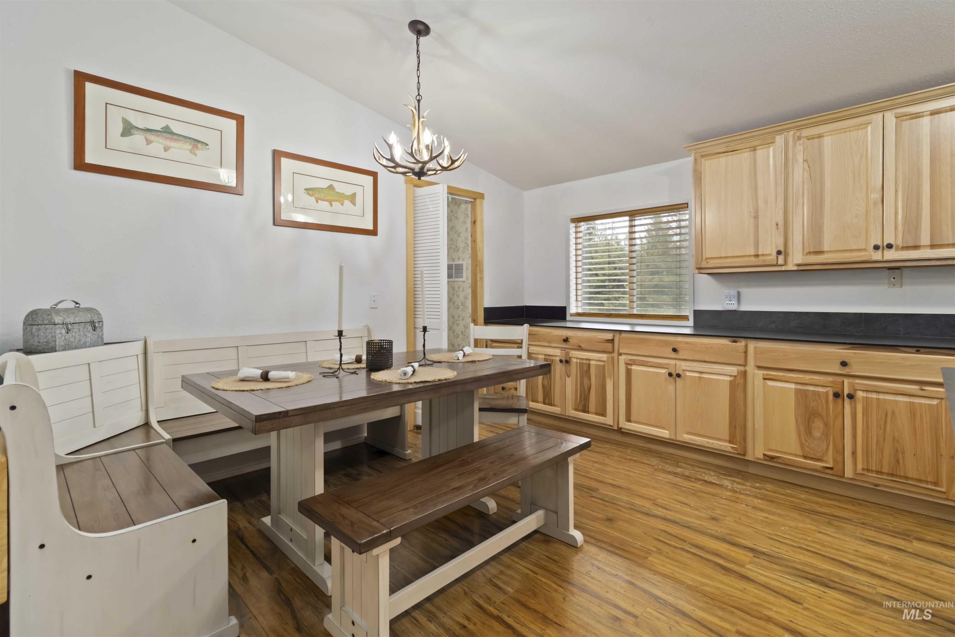 9592 Packer John Road Cascade, ID 83611 - Photo 15 of 47 Dining room featuring dark wood-type flooring, lofted ceiling, and a chandelier