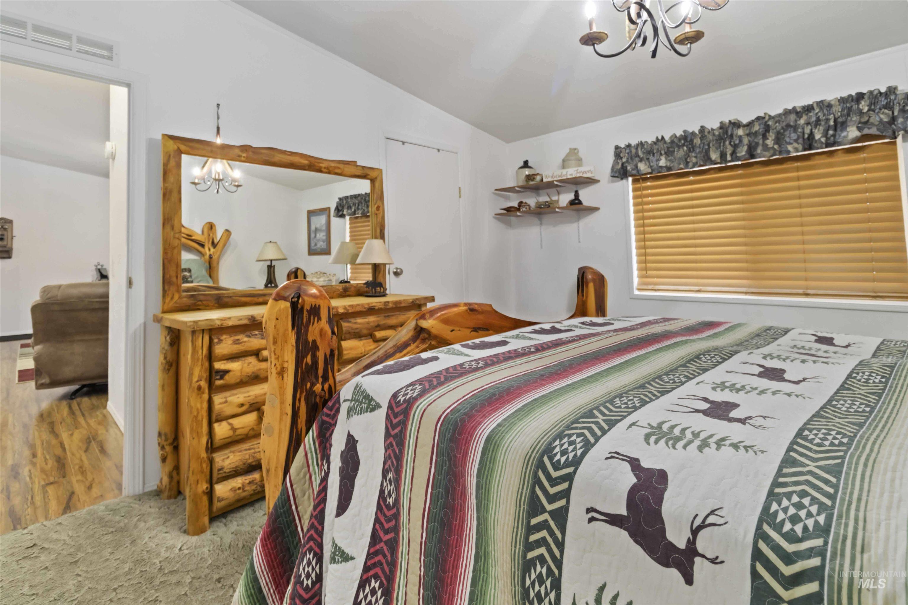 9592 Packer John Road Cascade, ID 83611 - Photo 21 of 47 Bedroom with a chandelier, lofted ceiling, and carpet