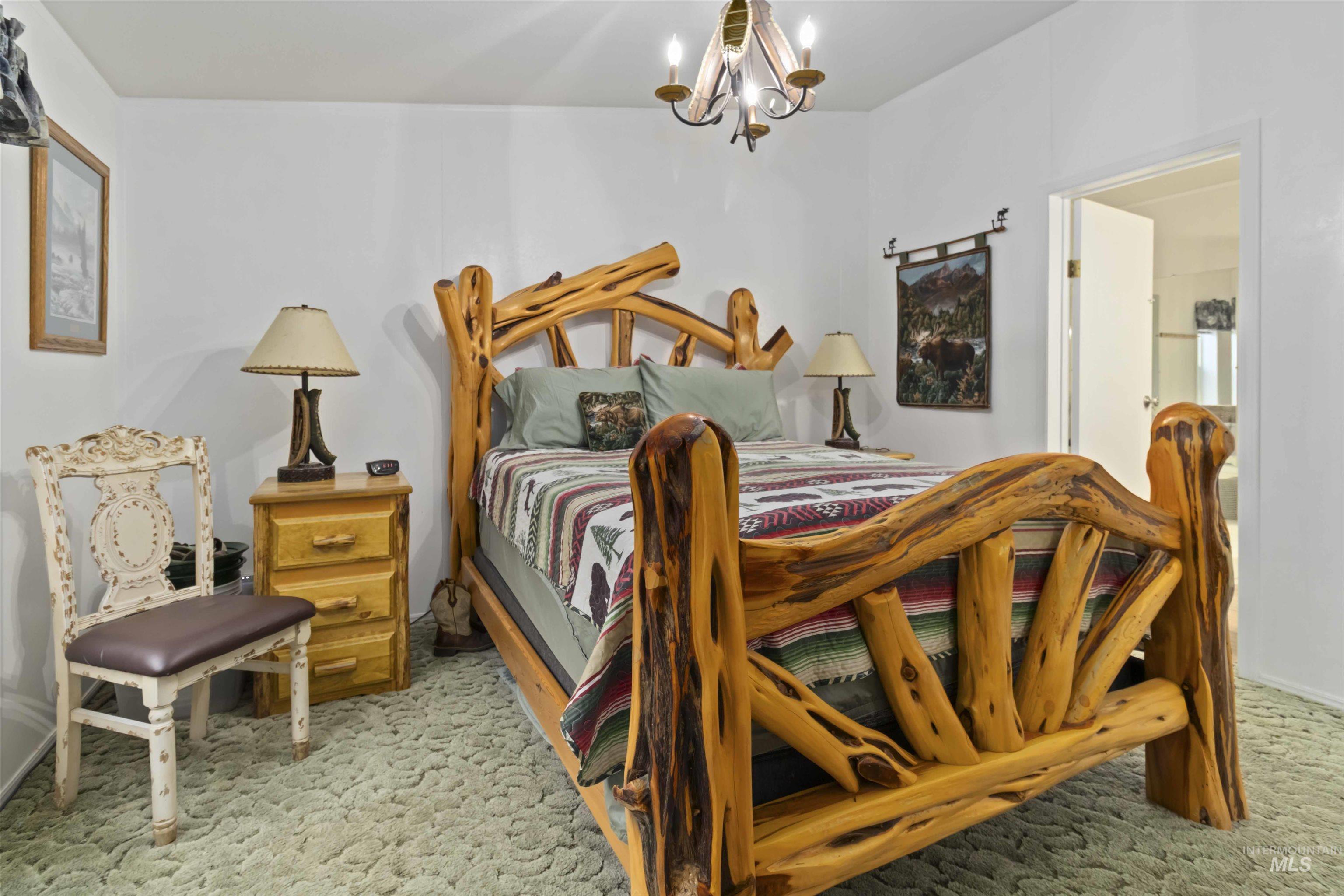 9592 Packer John Road Cascade, ID 83611 - Photo 24 of 47 Bedroom featuring a chandelier and light carpet