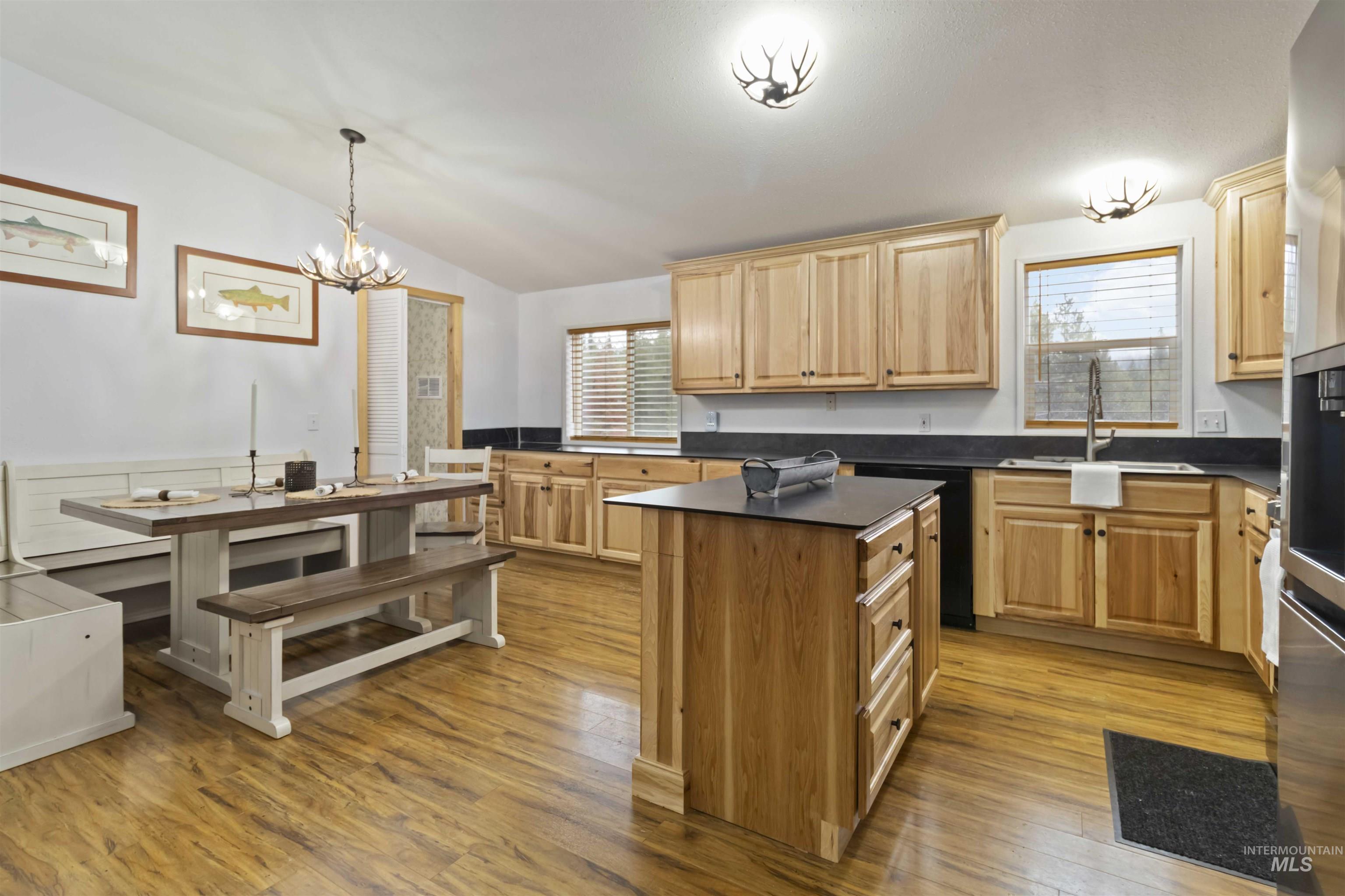 9592 Packer John Road Cascade, ID 83611 - Photo 40 of 47 Kitchen with dark countertops, lofted ceiling, a kitchen island, light wood-style flooring, and healthy amount of natural light