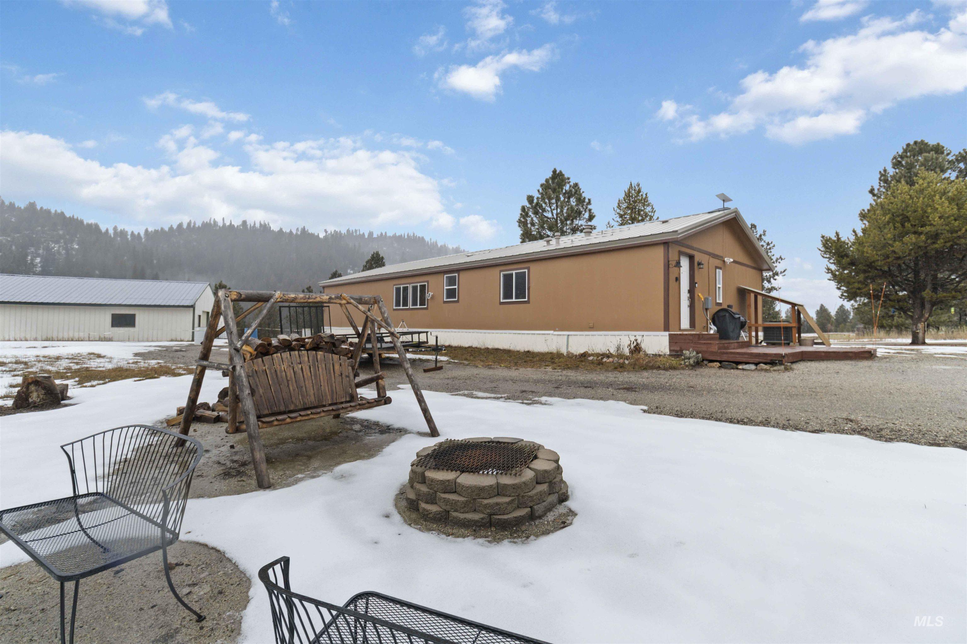 9592 Packer John Road Cascade, ID 83611 - Photo 4 of 47 Snow covered property with a fire pit, a deck, and a patio