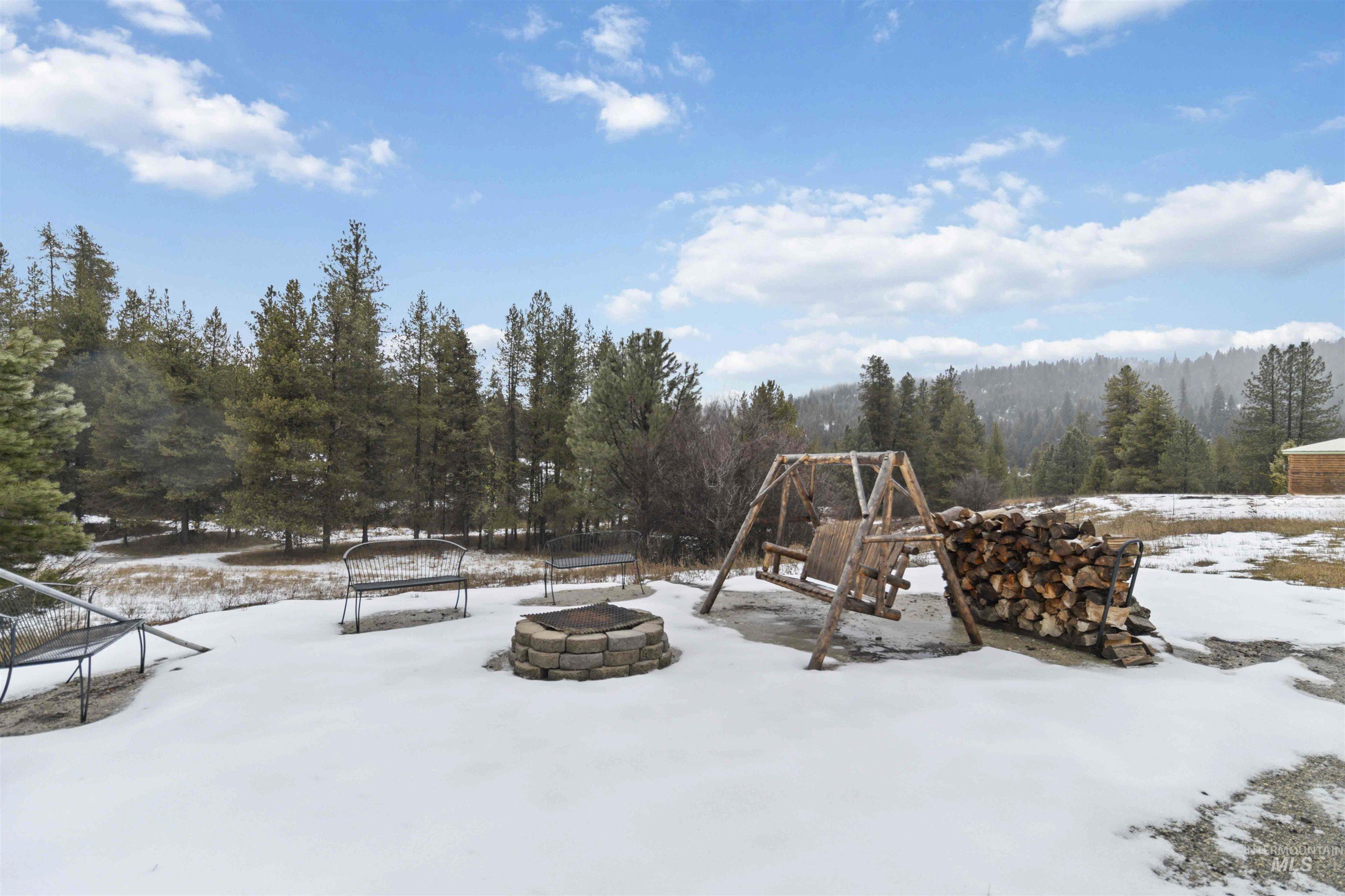 9592 Packer John Road Cascade, ID 83611 - Photo 43 of 47 Snowy yard with a fire pit and a patio area