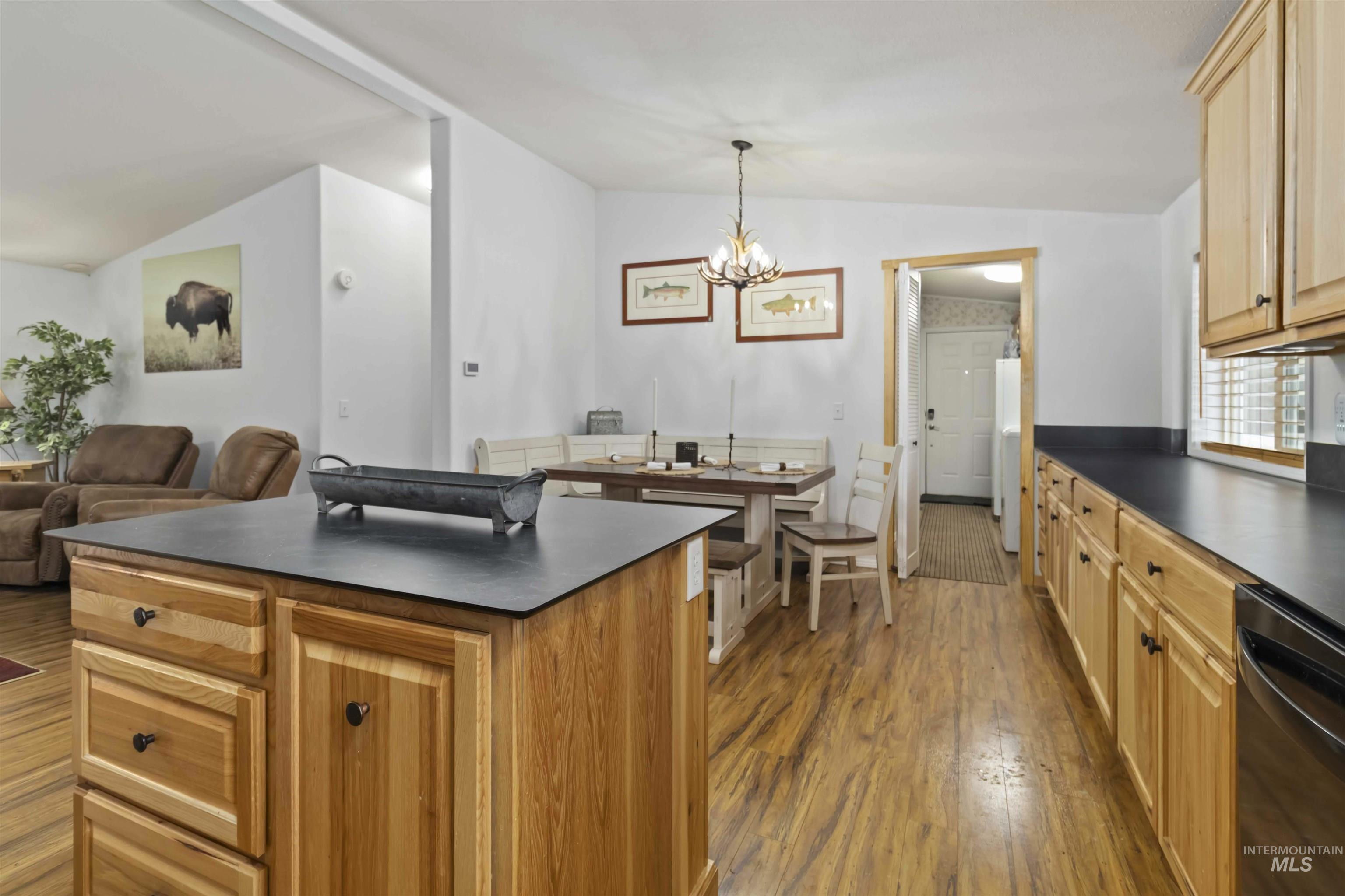 9592 Packer John Road Cascade, ID 83611 - Photo 7 of 47 Kitchen featuring dark countertops, lofted ceiling, dark wood-type flooring, dishwashing machine, and a kitchen island