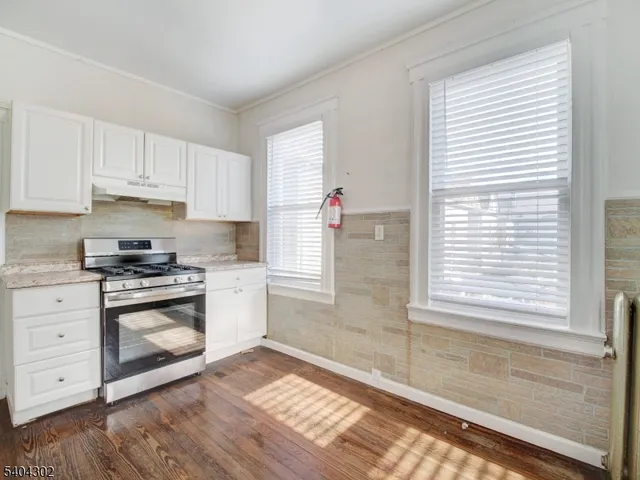 a kitchen with granite countertop white cabinets and white appliances