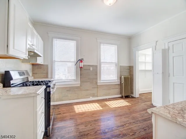 a kitchen with granite countertop a stove a sink and a refrigerator