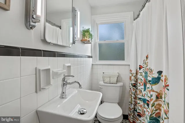 a bathroom with a sink a toilet and shower curtain