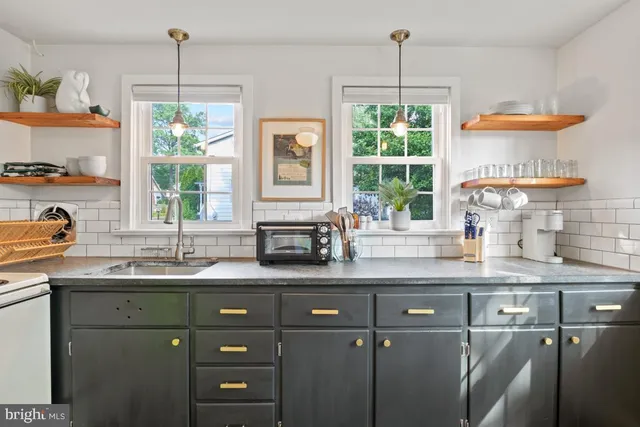 a kitchen with stainless steel appliances granite countertop a sink a window and cabinets