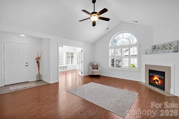 an empty room with a fireplace and wooden floor