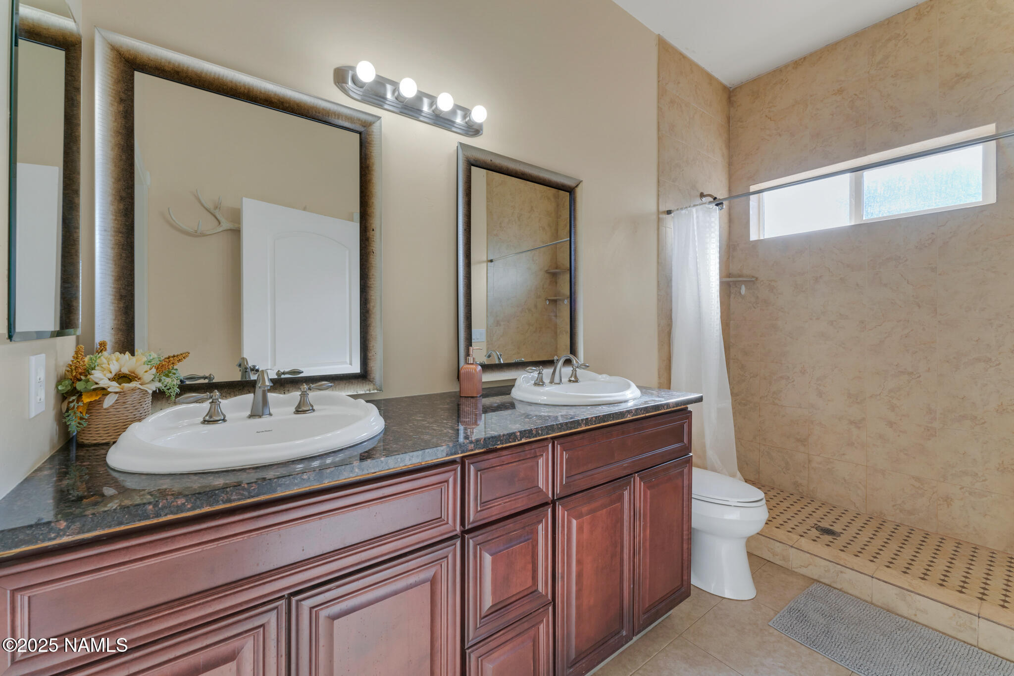 8752 South Lariat Road Williams, AZ 86046 - Photo 14 of 38 a bathroom with a granite countertop sink toilet a large mirror and shower