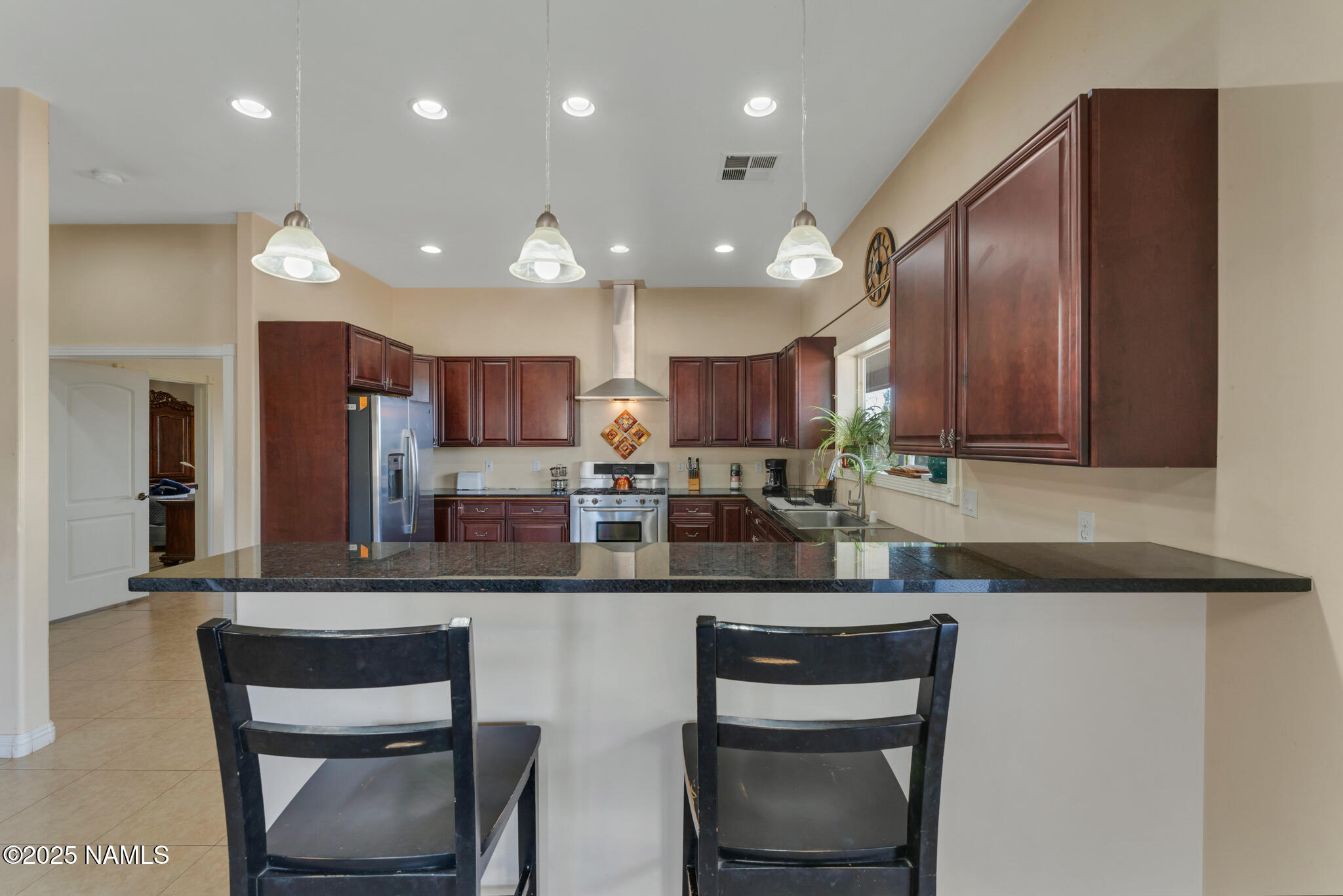8752 South Lariat Road Williams, AZ 86046 - Photo 5 of 38 a kitchen with kitchen island granite countertop wooden cabinets and a refrigerator