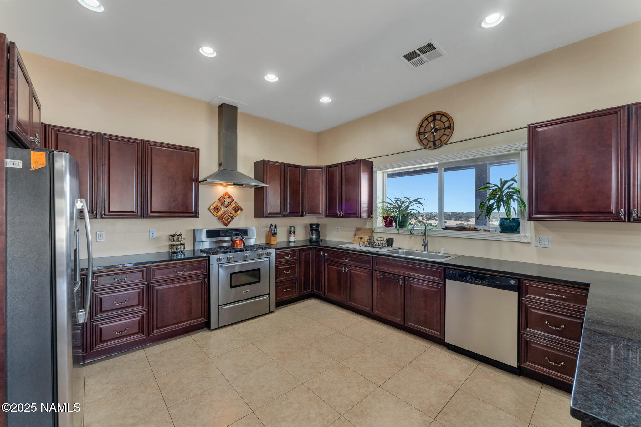 8752 South Lariat Road Williams, AZ 86046 - Photo 6 of 38 a kitchen with stainless steel appliances granite countertop wooden cabinets a stove a sink and a refrigerator