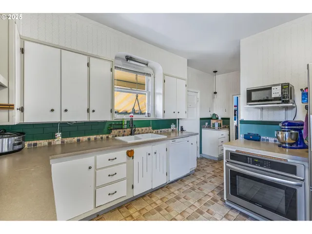 a kitchen with granite countertop a stove a sink and a microwave