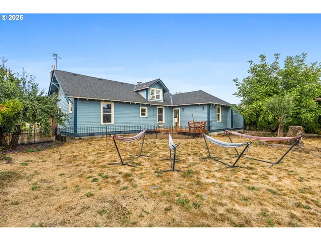 a backyard of a house with wooden floor chairs