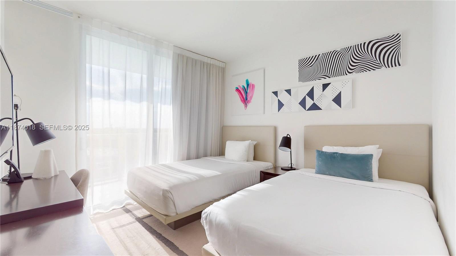 4010 South Ocean Drive, Unit R1004 Hollywood, FL 33019 - Photo 11 of 24 a bedroom with two beds and a window