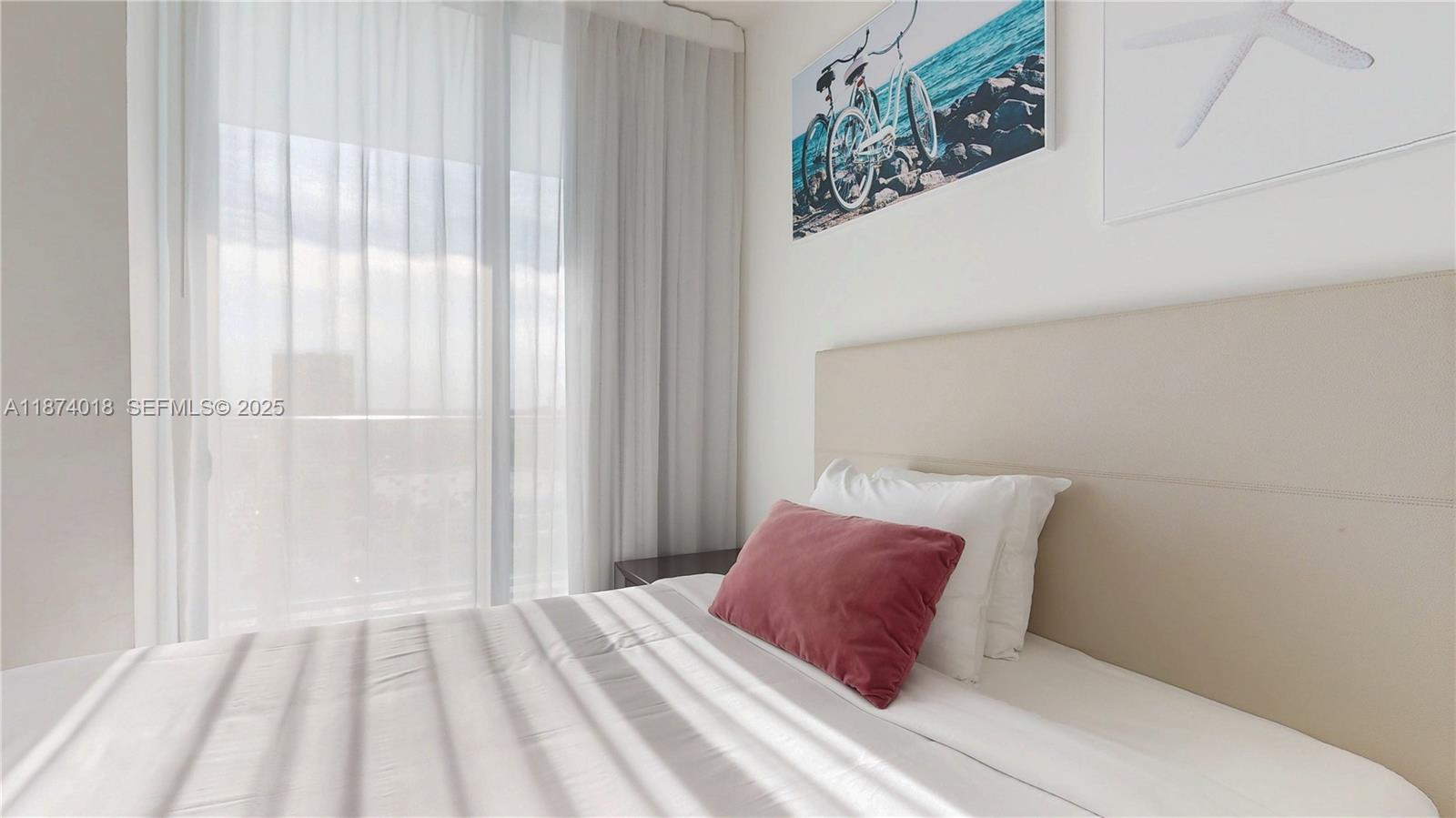 4010 South Ocean Drive, Unit R1004 Hollywood, FL 33019 - Photo 17 of 24 a bedroom with a large bed and a wooden floor