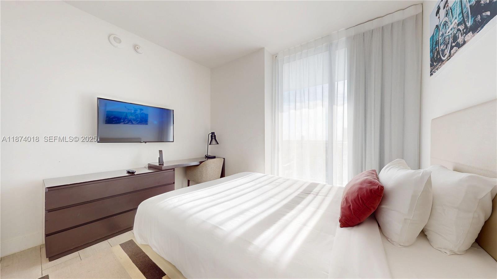 4010 South Ocean Drive, Unit R1004 Hollywood, FL 33019 - Photo 18 of 24 a bedroom with a bed and a night stand