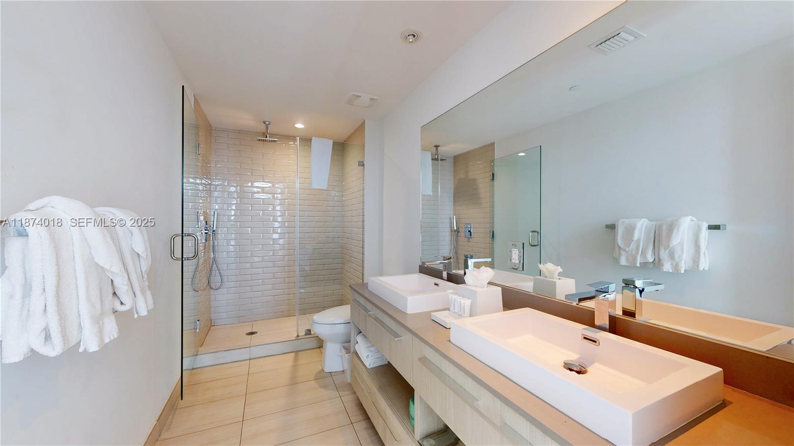 4010 South Ocean Drive, Unit R1004 Hollywood, FL 33019 - Photo 22 of 24 a bathroom with a double vanity sink large mirror and shower