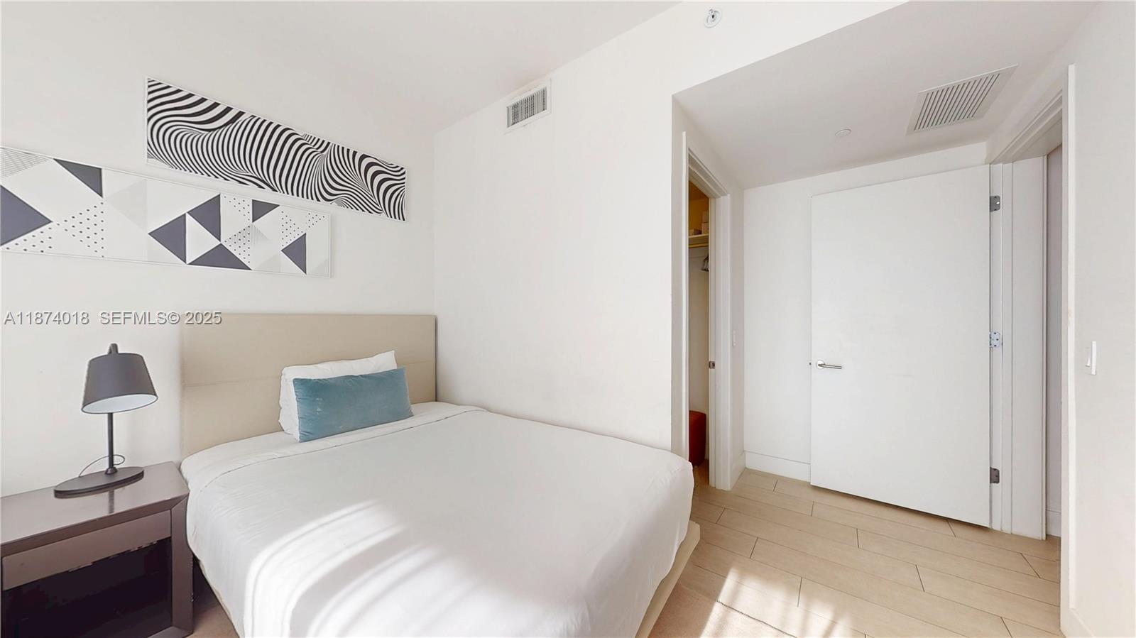 4010 South Ocean Drive, Unit R1004 Hollywood, FL 33019 - Photo 10 of 24 a bedroom with a bed and a lamp