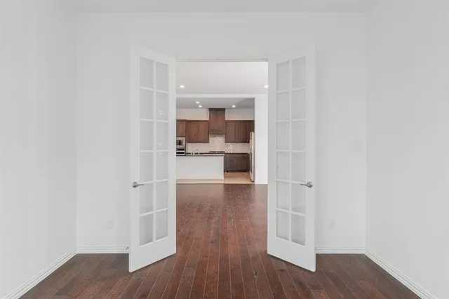 a view of a kitchen with wooden floor and a window