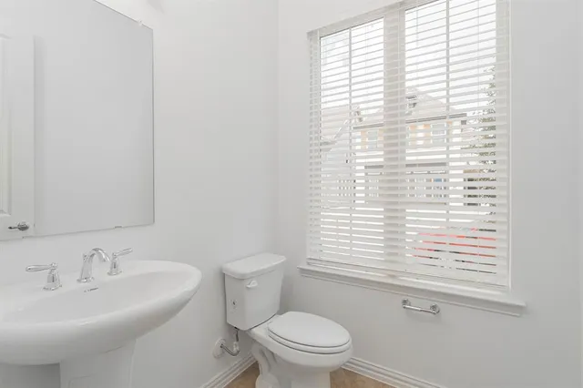a bathroom with a sink a toilet and a window