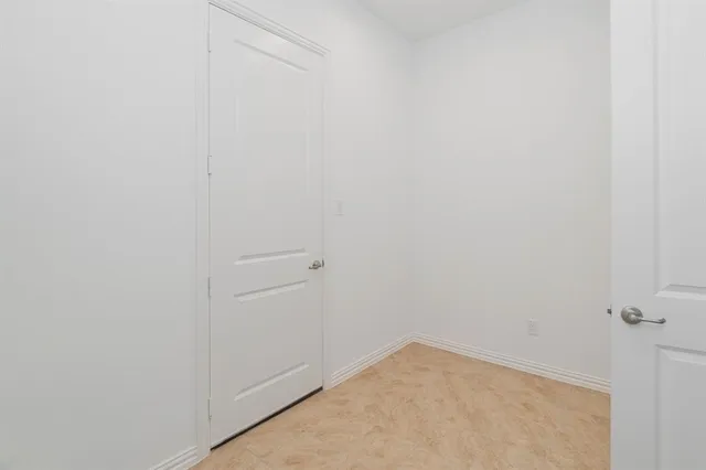 an empty room with wooden floor chandelier fan and windows