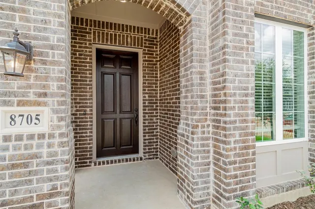 a view of a door with brick walls