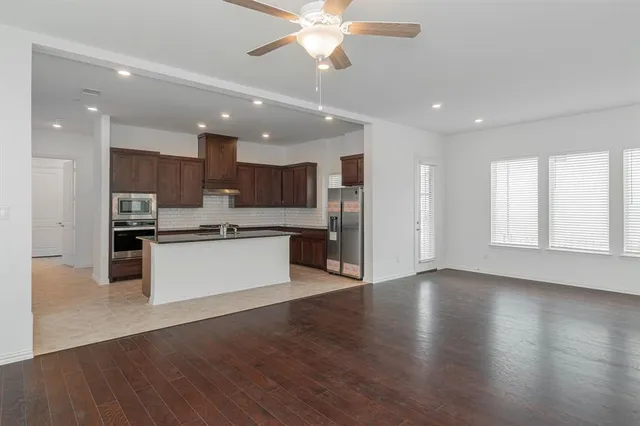 a large kitchen with stainless steel appliances granite countertop a large counter top a sink and a stove