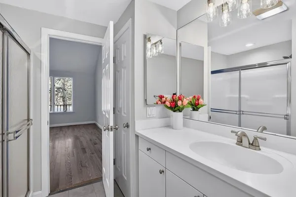 a bathroom with a granite countertop sink a mirror and a shower