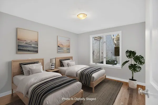 a bedroom with two beds and a potted plant