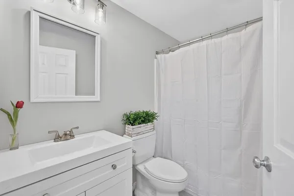 a bathroom with a sink vanity mirror and toilet