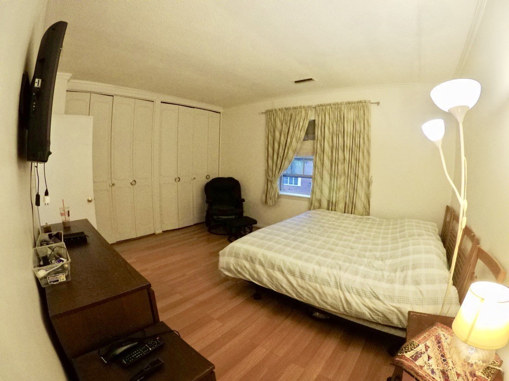 210 Lake Shore Road, Unit 3 Boston, MA 02135 - Photo 8 of 20 a bedroom with a bed and a chandelier