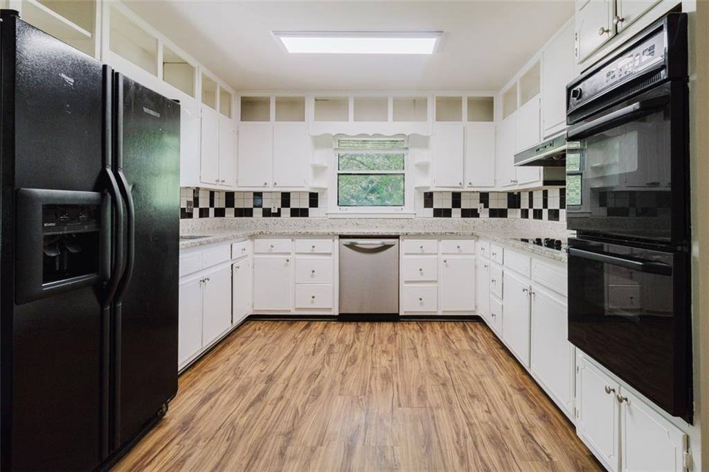 11433 Panhandle Road Hampton, GA 30228 - Photo 9 of 22 a kitchen with stainless steel appliances a sink cabinets and wooden floor