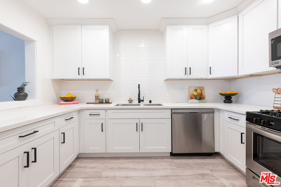 839 Larrabee Street, Unit 6 West Hollywood, CA 90069 - Photo 16 of 34 a kitchen with cabinets appliances and a window
