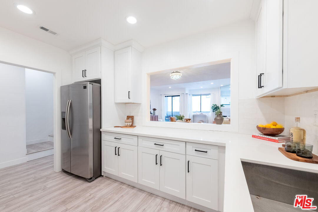 839 Larrabee Street, Unit 6 West Hollywood, CA 90069 - Photo 17 of 34 a kitchen with white cabinets and stainless steel appliances