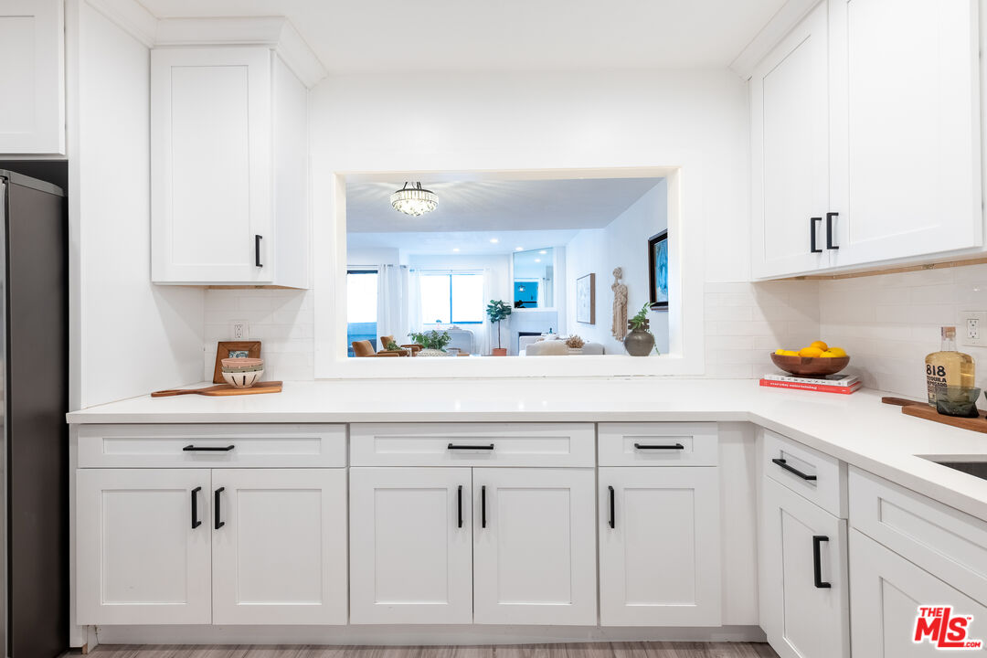 839 Larrabee Street, Unit 6 West Hollywood, CA 90069 - Photo 18 of 34 a kitchen with white cabinets and sink