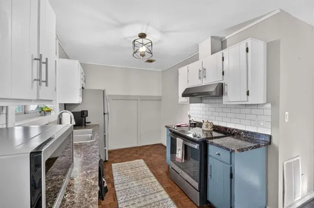 a kitchen with stainless steel appliances granite countertop a sink stove and cabinets