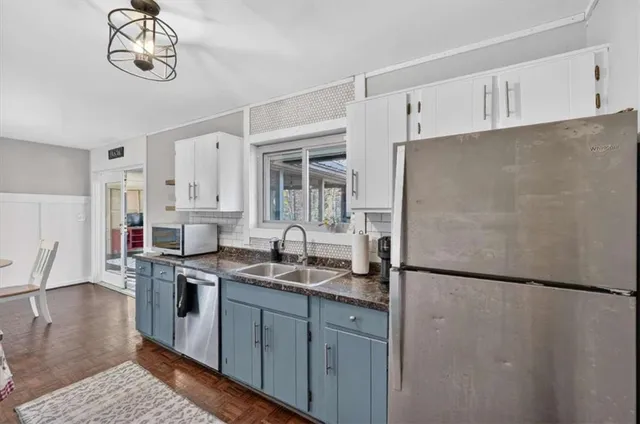 a kitchen with stainless steel appliances granite countertop a refrigerator sink and white cabinets