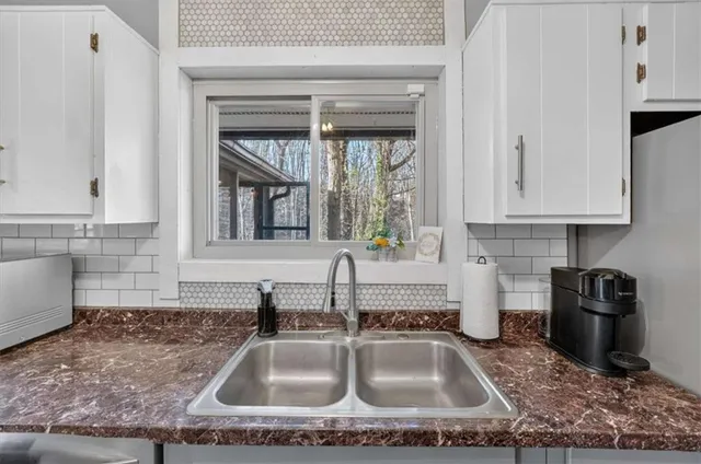 a kitchen with granite countertop a sink and a stove