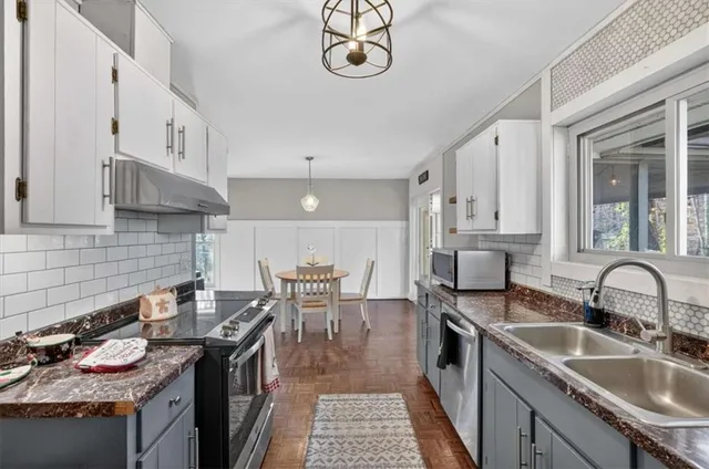 a kitchen with granite countertop a sink a stove and wooden cabinets