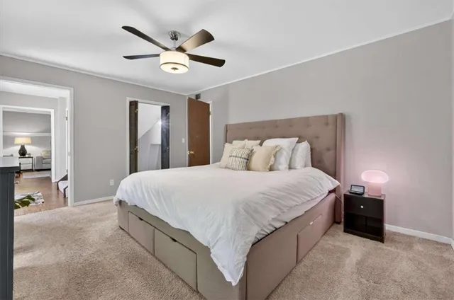 a spacious bedroom with a bed and ceiling fan