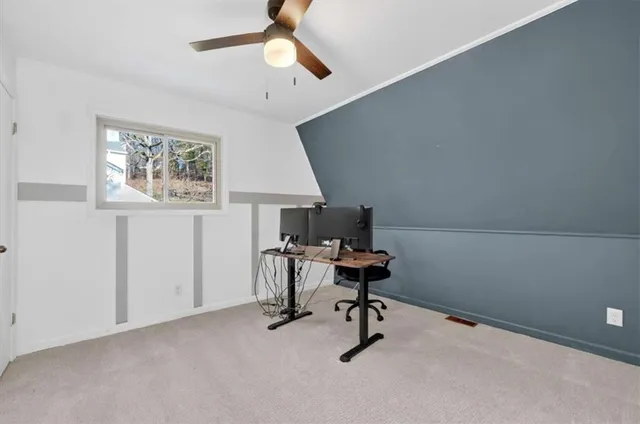 a view of a workspace with furniture and a window