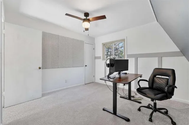 a view of a workspace with furniture and a window