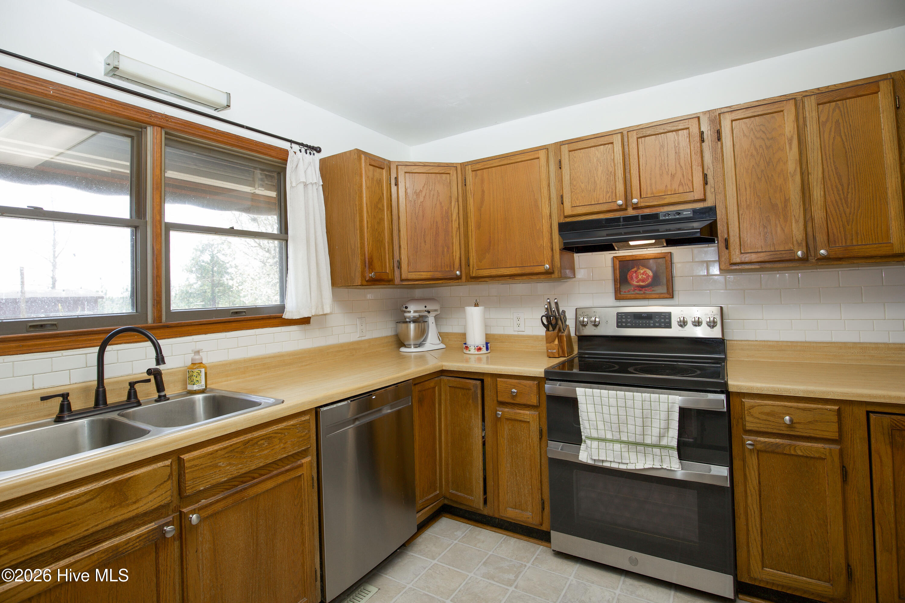 124 Joseph Road Aberdeen, NC 28315 - Photo 11 of 59 Kitchen with window over sink providing natural light and view of property, along with full appliance layout.