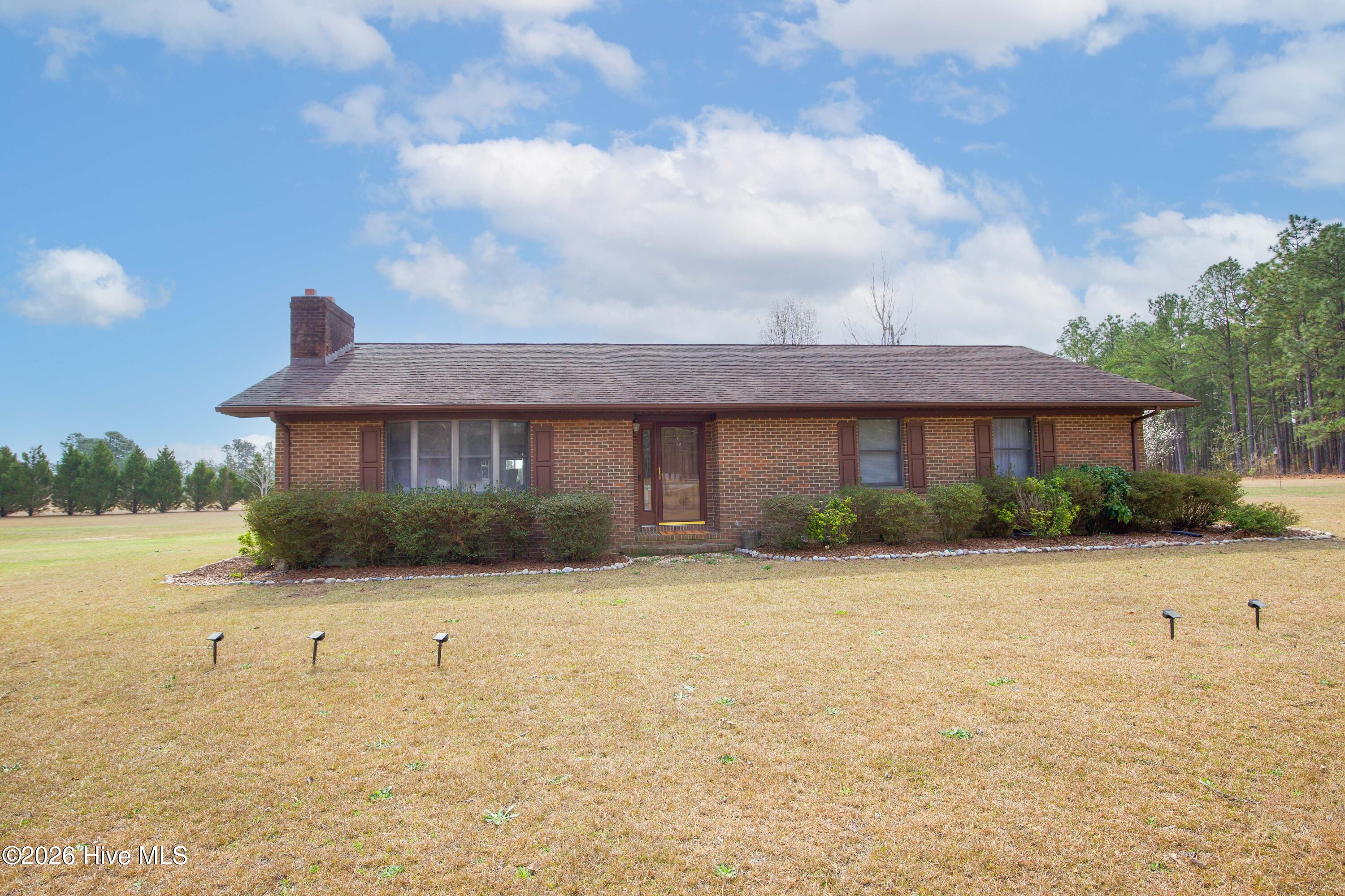 124 Joseph Road Aberdeen, NC 28315 - Photo 27 of 64 Front exterior of the brick ranch home at 124 Joseph Road. This single level home offers three bedrooms and two bathrooms on approximately 5.06 acres in Moore County. The property features a large open yard and a quiet rural setting while remaining conveniently located near Aberdeen, Southern Pines, Pinehurst, and commuter routes to Fort Bragg and Camp Mackall.