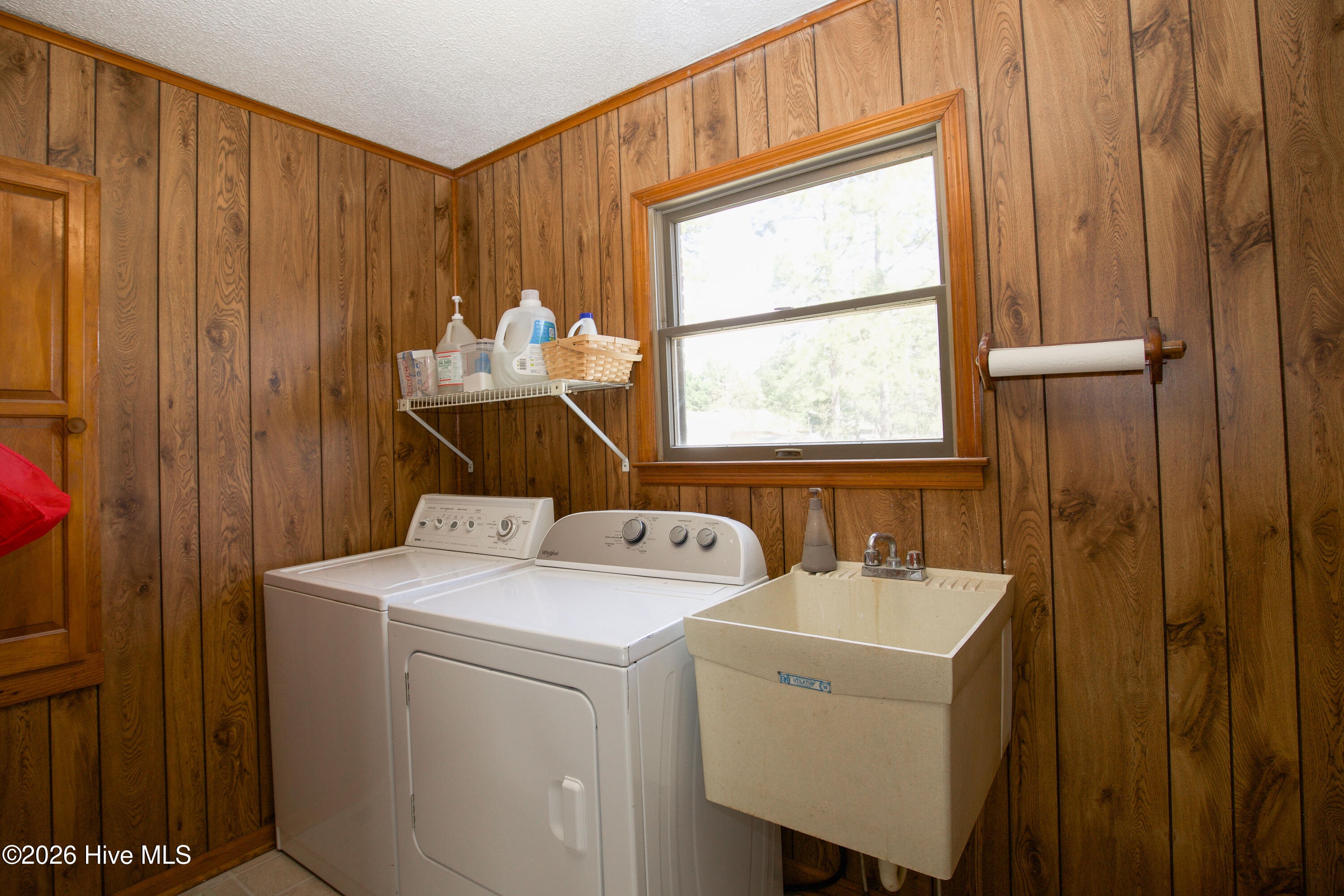 124 Joseph Road Aberdeen, NC 28315 - Photo 34 of 59 Laundry room with a sink and a washer and dryer setup with additional workspace.