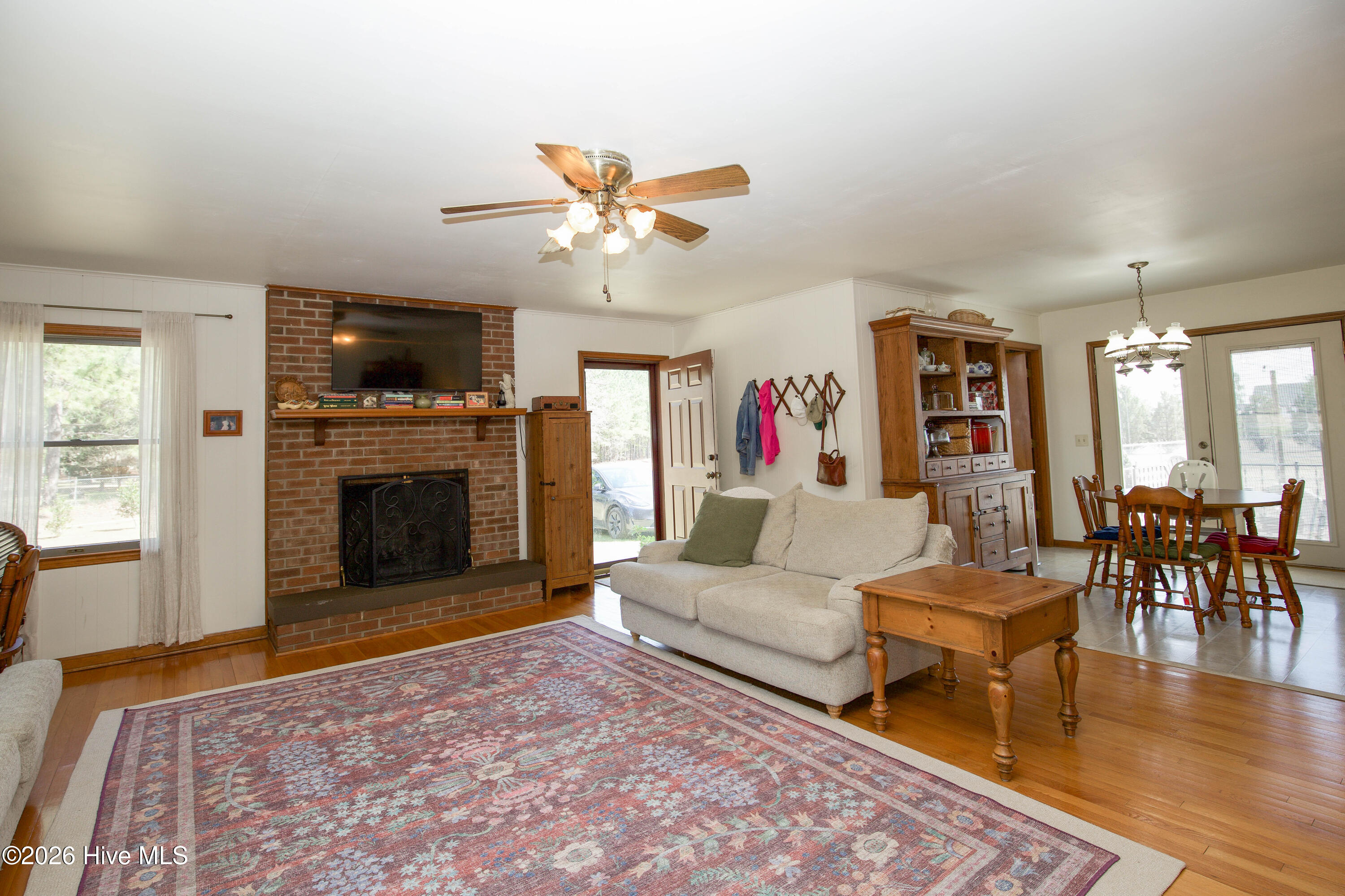 124 Joseph Road Aberdeen, NC 28315 - Photo 4 of 59 This image shows the main living room of this wonderful single-level home in Aberdeen, NC, viewed from the front entry. The space highlights an open-concept layout with hardwood flooring, strong natural light, and a functional connection to the dining area, appealing to buyers seeking comfortable everyday living and entertaining space on acreage near Southern Pines and Fort Bragg.