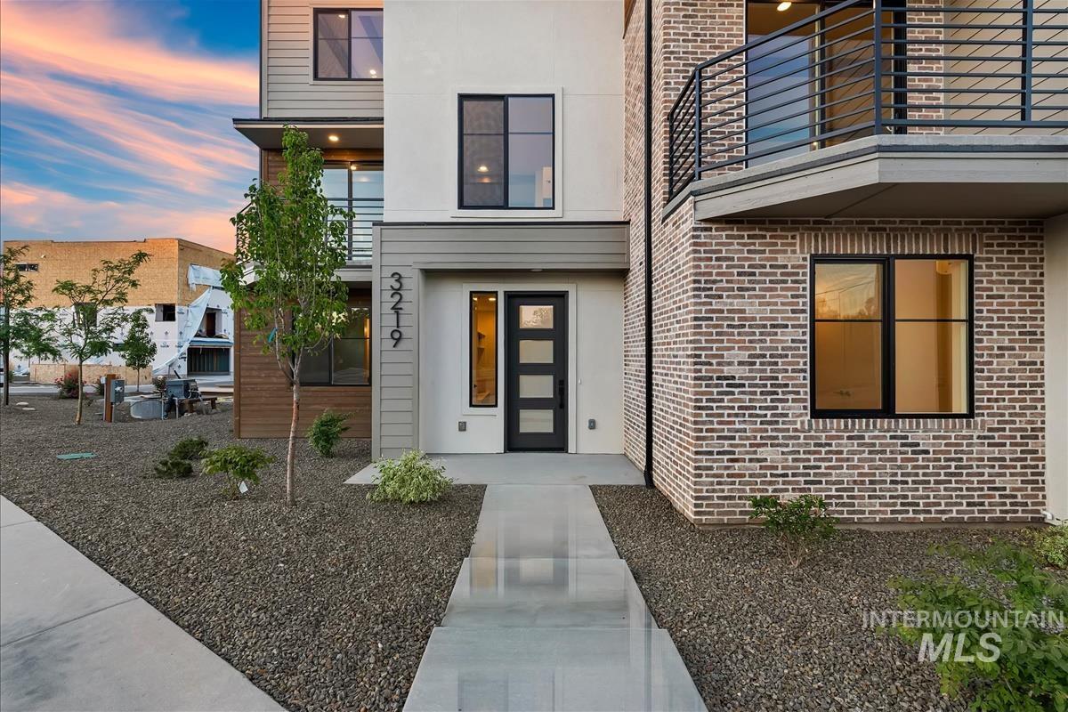 3219 West Moore Street Boise, ID 83702 - Photo 2 of 36 Modern multi-story exterior featuring a prominent brick facade and a multi-pane glass entry door