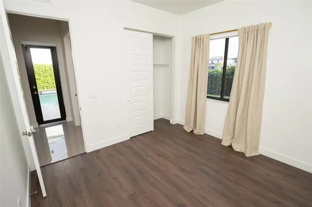 an empty room with wooden floor and entrance