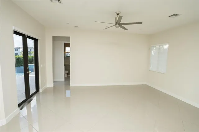 an empty room with fan and windows