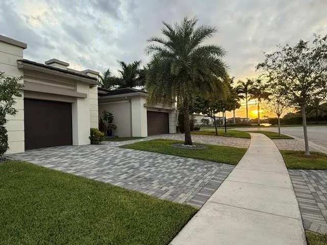 a front view of a house with a yard and trees